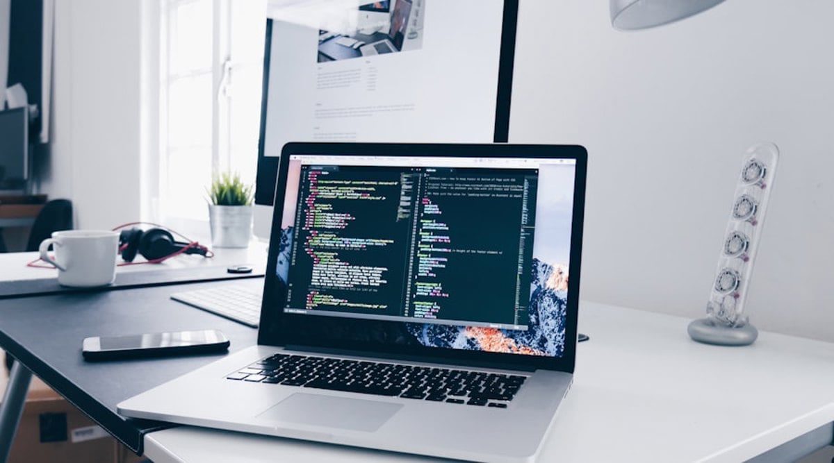 Profissional trabalhando em ambiente de coworking com laptop — tecnologia e estrutura regulamentada