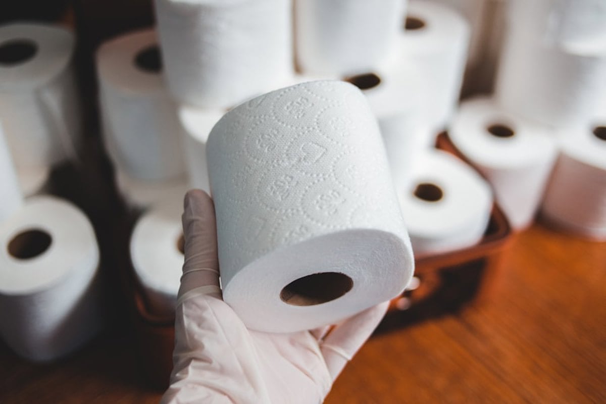 Pessoa higienizando piso de canil com produto de limpeza