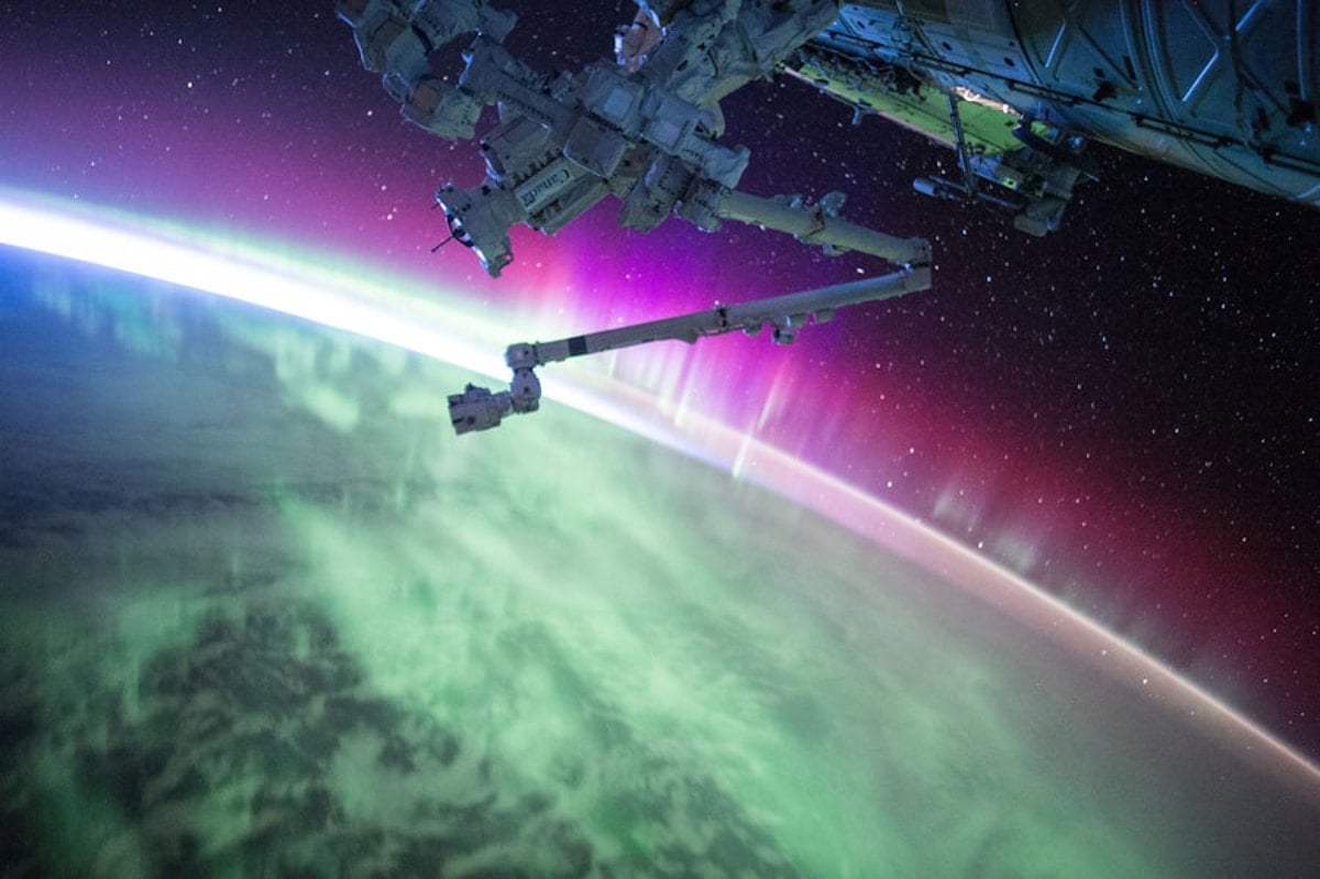 Vista do espaço com estrelas e a Terra ao fundo, representando a missão histórica de Laika