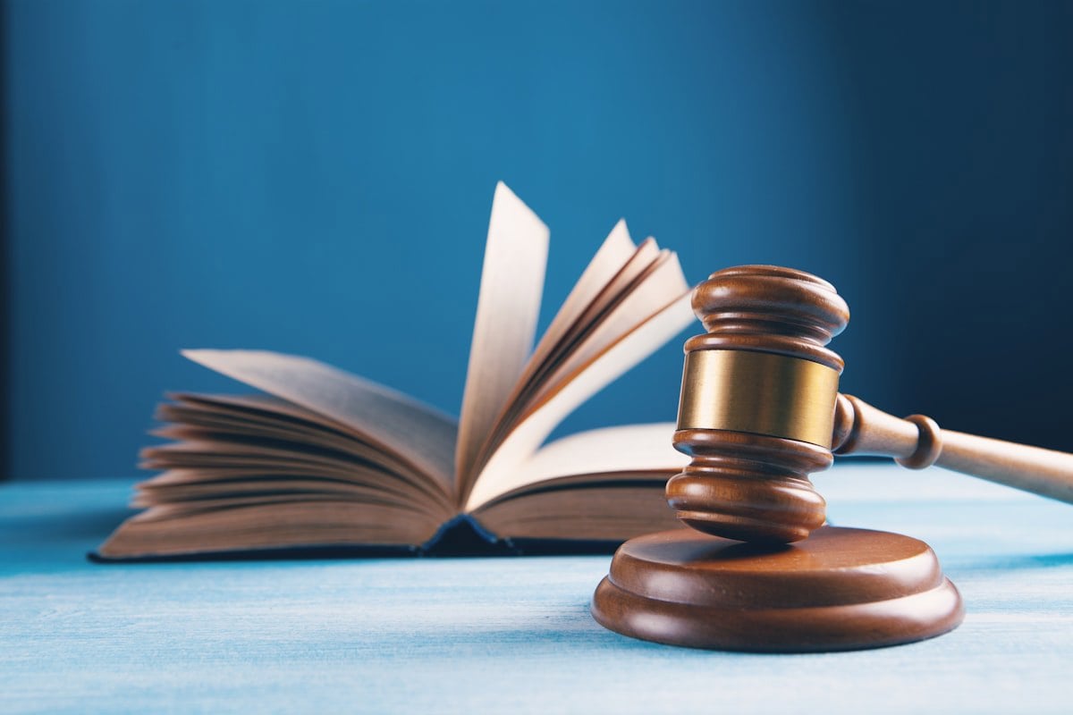 Martelo de juiz sobre livro de leis, representando a Constituição Federal e a legislação de proteção animal
