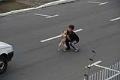 Criança socorre cachorro atropelado no meio da rua.