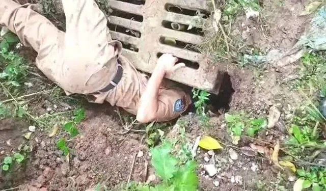 Policiais Militares entram em bueiro para salvar filhotes de cachorro.