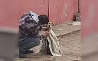 Mulher agasalha cachorro de rua